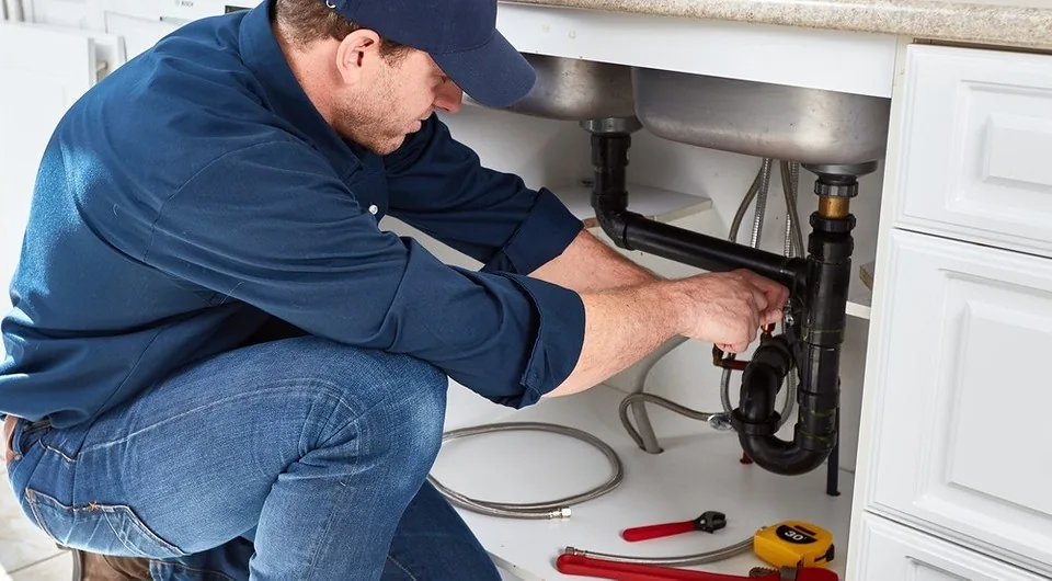 Plumber examining sink drain connections